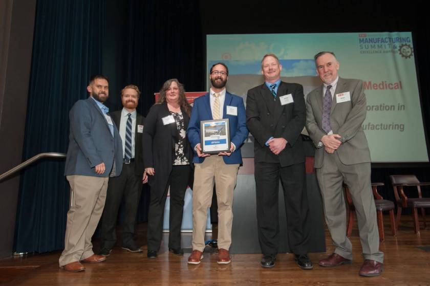 Group of BMP Medical team members on stage receiving manufacturing excellence award.