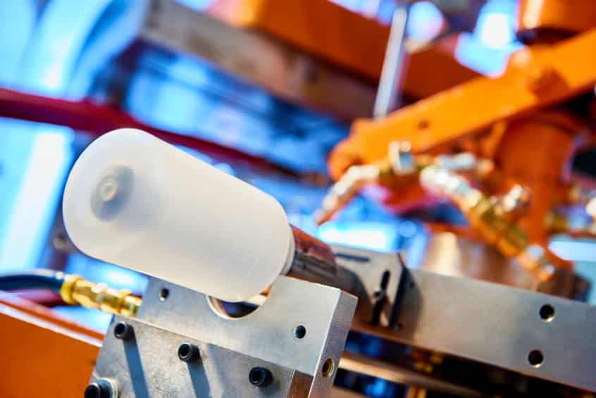 Close-up of custom bottle mounted on industrial equipment.