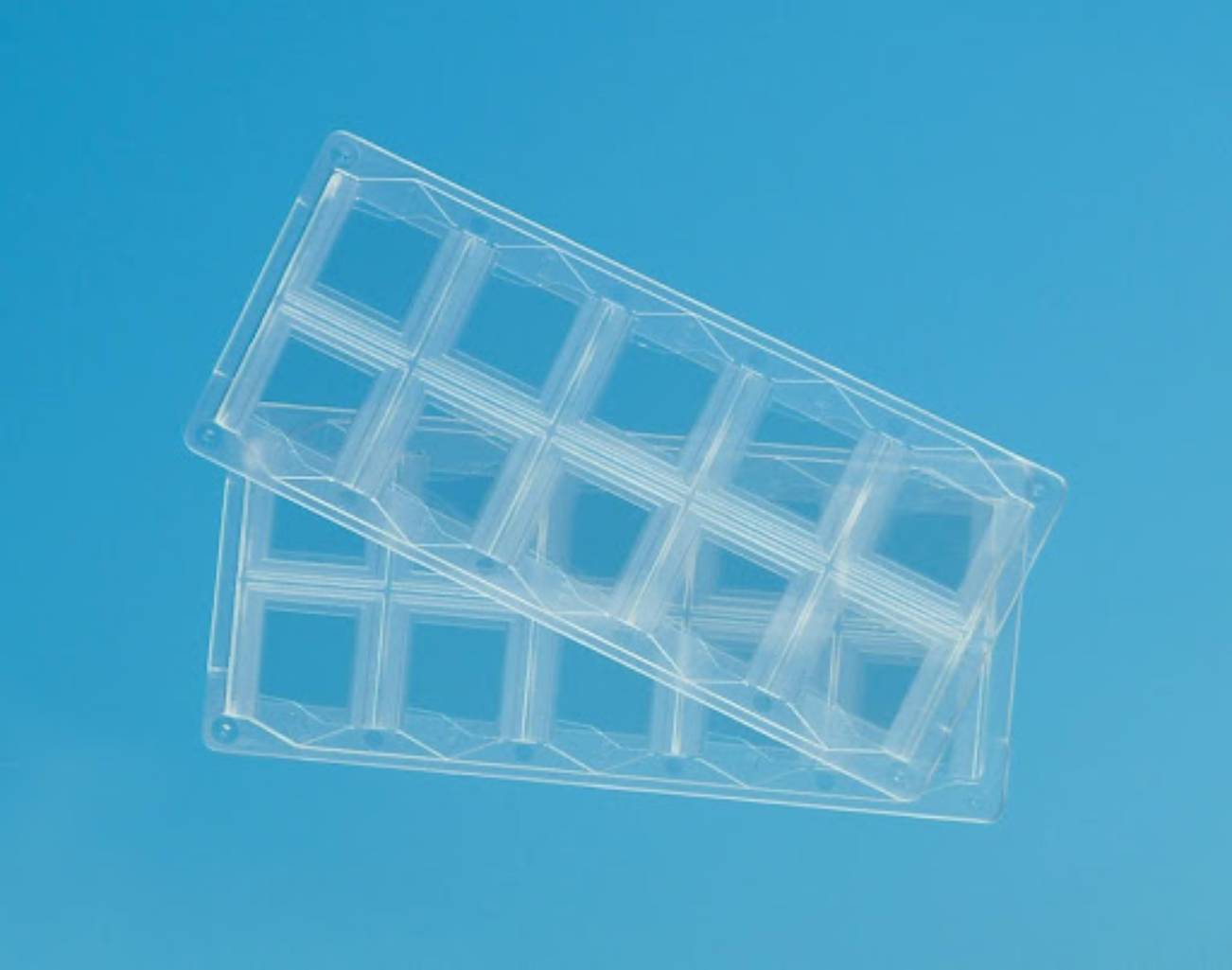 Clear plastic multi-well trays designed for laboratory use.