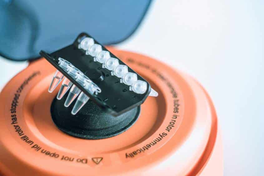 Close-up of a microcentrifuge rotor loaded with clear tubes.